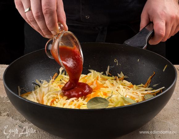 Добавьте кетчуп, лавровый лист. Накройте крышкой и тушите на медленном огне, помешивая.