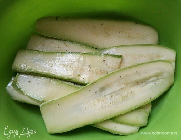 В это время можно заняться кабачками. Нарезать их острым ножом на пластины. Я пробовала овощечисткой, но получается довольно тонко, что мне не понравилось. Посолить.