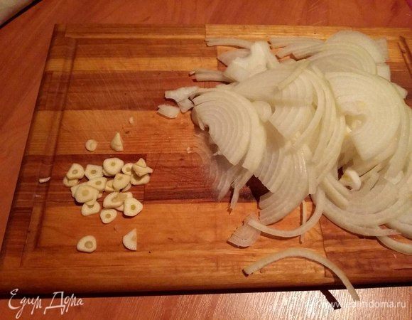  Через сутки приступим к готовке. Лук нарезать полукольцами, чеснок — тонкими колечками. 