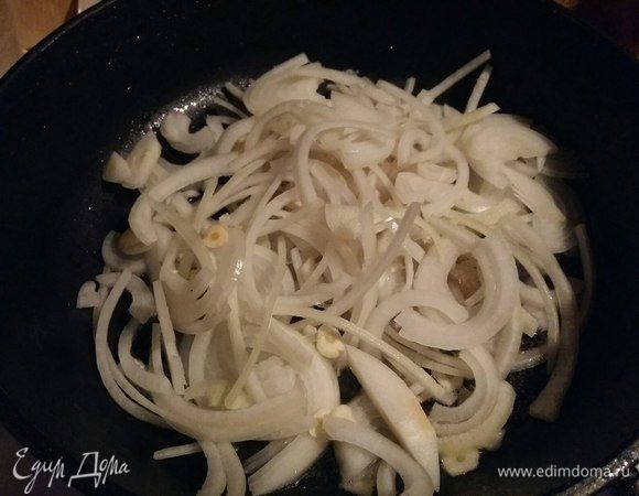 Далее в сковороде, где готовилось мясо, обжарить лук с чесноком в течение 5–7 минут.