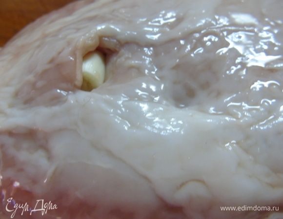 Мясо моем и просушиваем бумажной салфеткой. Делаем надрезы и вставляем чеснок.