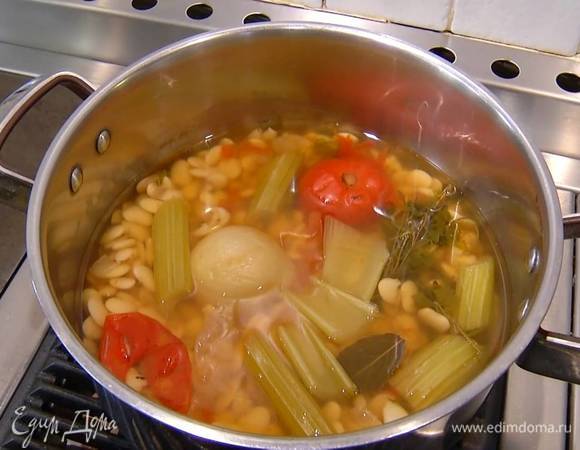 Фасоль замочить на ночь, затем залить водой, добавить помидор целиком, очищенную луковицу, морковь и зубчик чеснока, стебель сельдерея, пучок петрушки, лавровый лист и отварить до готовности.