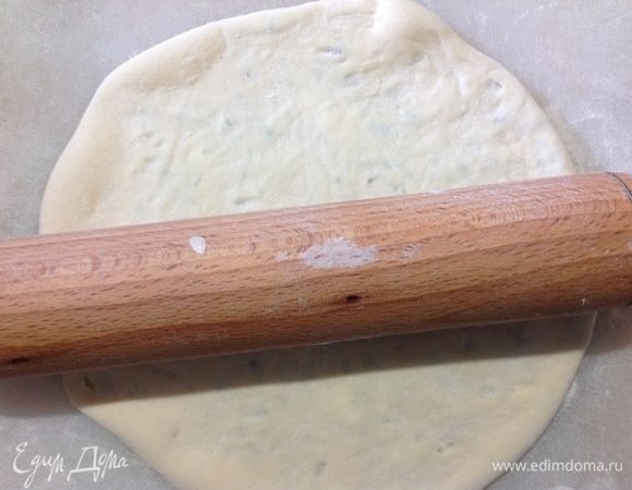 Теперь сначала руками немного придавливаем по лепешке, чтобы воздух вышел, и затем скалкой аккуратно раскатываем в лепешку.