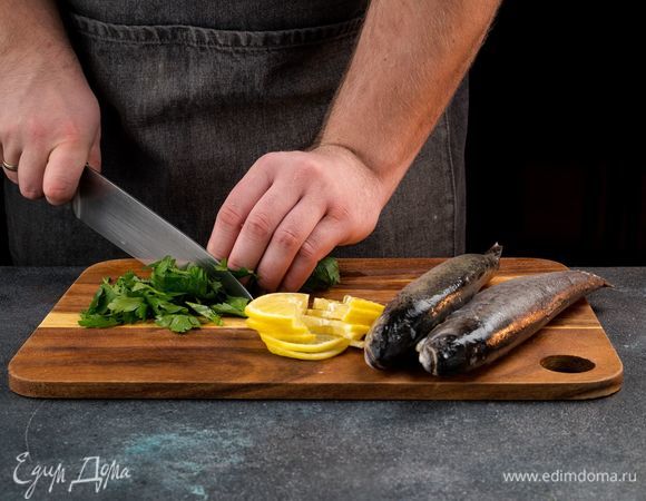 Лимон нарежьте кружочками и каждый разрежьте пополам. Мелко нарубите петрушку.