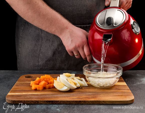 Отварите куриные яйца и морковь. Очистите их и нарежьте на кусочки. Нарежьте лук. Лук залить кипятком на 5 мин. 