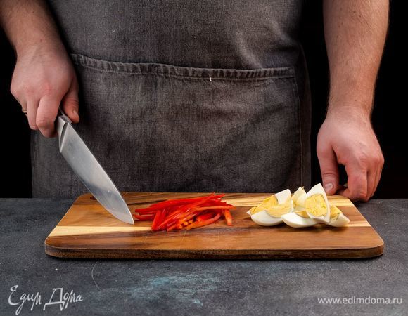 Отварите яйца, остудите и нарежьте крупными дольками. Болгарский перец нарежьте тонкой соломкой. 