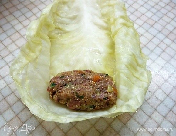 На край капустного листа выкладываем немного начинки.