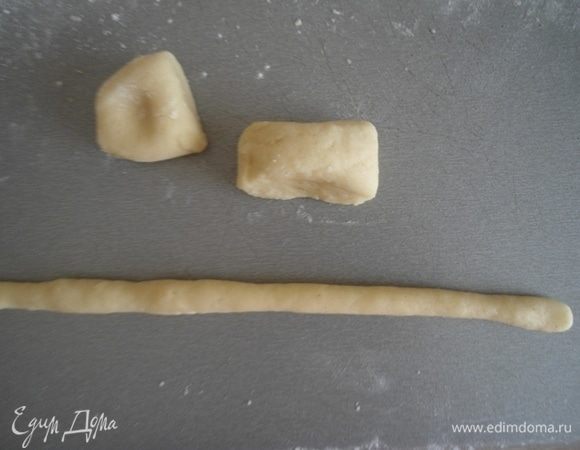 Разделить тесто на 2 части, скатать из каждой колбаску и поделить на одинаковые кусочки, примерно по 20–25 граммов. Из каждого кусочка скатать колбаску, чтобы края были чуть тоньше середины.
