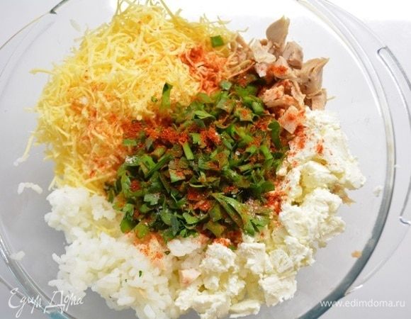 Подготовим все продукты для начинки, пока размораживается тесто. Рис ТМ «Националь» отварить до полуготовности, курицу отварить, отделить от кости и кожи. Твердый сыр натереть, фету помять вилкой. Зелень мелко измельчить.