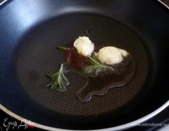 Готовим заливку. Обжарим на масле раздавленный зубчик чеснока и веточку розмарина.