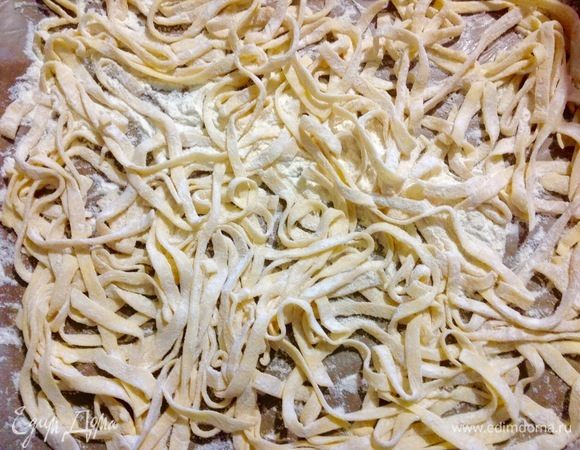 Разматываем каждый кусочек теста, выкладываем на доску присыпанную мукой и присыпаем мукой сверху, вструшиваем каждый раз лапшу так чтобы она хорошо обваливалась в муке, каждый раз после разрезания каждого рулетики теста.