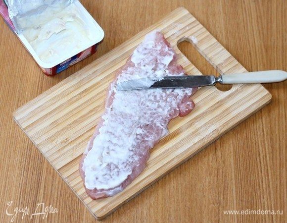 Смазать кусочки мяса плавленным сыром.
