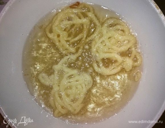 Выдавливаем тесто в виде спиралей в кипящее масло. Жарится оно очень быстро, буквально по несколько минут с каждой стороны.