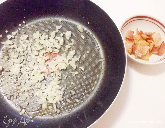 Переложить хрустящий бекон в отдельную миску. На этой же сковороде обжарьте мелко нарезанный репчатый лук в течение минуты. 