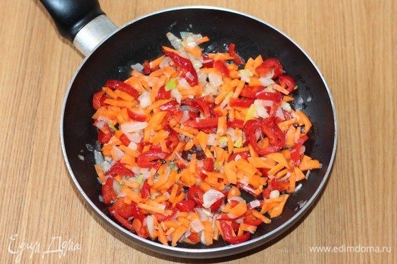 Добавить в сковороду очищенные и нарезанные соломкой морковь и сладкий перец. Тушить до готовности овощей.