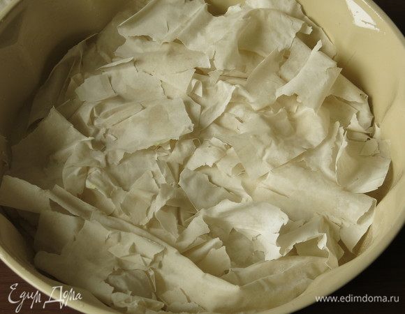 Дно формы смазываем маслом, выкладываем кусочки теста фило.