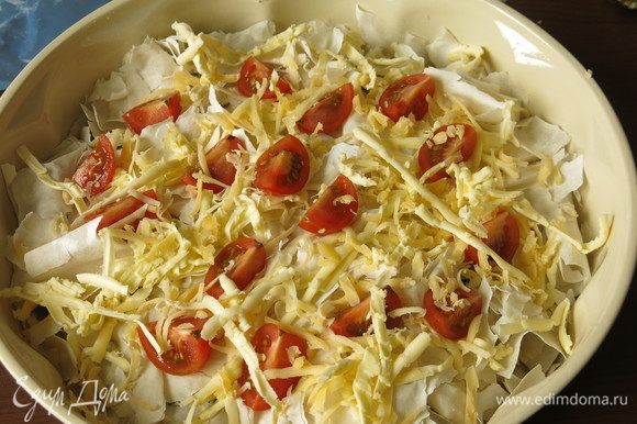 Выкладываем дольки томатов черри, чуть посыпаем сыром и отравляем на 40 минут в духовку при 180°С.