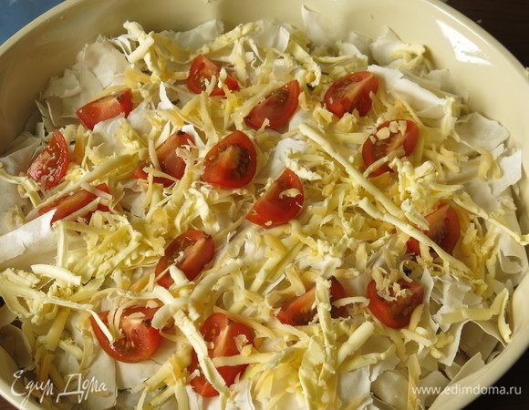 Выкладываем дольки томатов черри, чуть посыпаем сыром и отравляем на 40 минут в духовку при 180°С.