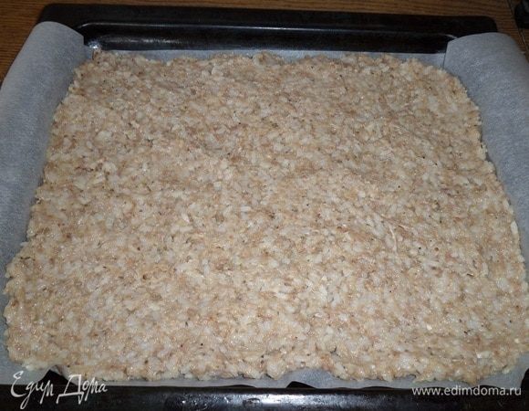 Противень застилаем пергаментом. На пергамент выкладываем рисово-мясную массу. Разравниваем.