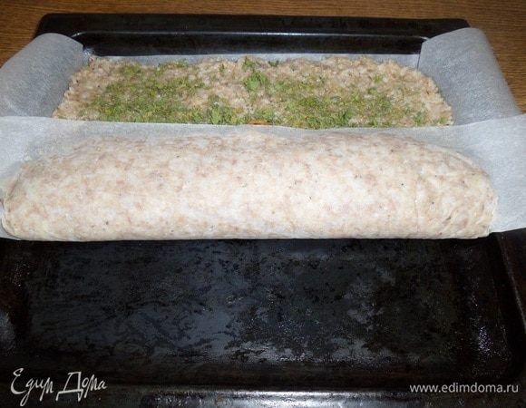 Приподнимая один край пергамента, накрываем овощную начинку рисово-мясной основой.