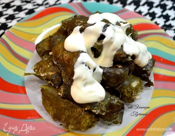 Подать долму с соусом, посыпав свежей зеленью.
