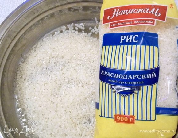 Рис  для этого рецепта можно брать любой. Если любите рассыпчатый, то возьмите пропаренный от ТМ «Националь». Мои предпочитают более вязкий вариант, поэтому я беру круглозерный рис ТМ «Националь». Отмерить нужное количество и промыть. Положить ровным слоем в форму для запекания.
