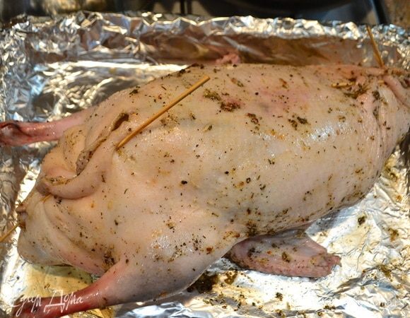 Наполнить утку яблоками, хурмой и финиками. Сшить или закрепить шпажками кожу утки. Выложить утку на противень, застеленный фольгой. Сверху также накрыть фольгой и выпекать при 180–200°С в течение 2 часов, каждые полчаса поливать утку салом, которое топится с утки.