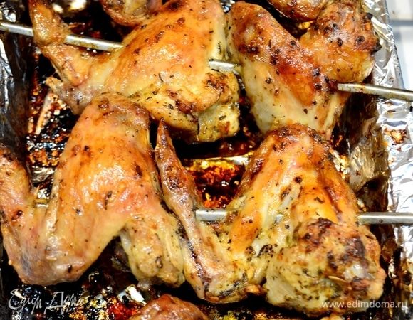 Крылышки надеваем на шампуры, накрываем фольгой и доводим до готовности в духовке при 180°С. Далее снимаем фольгу и, переворачивая, включаем гриль и ждем, когда крылышки подрумянятся.