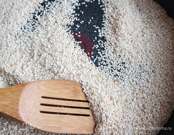 Обжарить семена кунжута на сухой сковороде до слегка золотистого цвета. Важно: не пережарить, потому помешивайте лопаточкой и следите за процессом.
