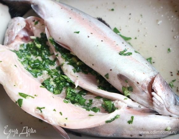 Измельчить зелень. Шпинат и петрушку можно заменить кинзой, по вашему вкусу. Чеснок почистить, пропустить через пресс, смешать с  зеленью, поместить в брюшко форели.