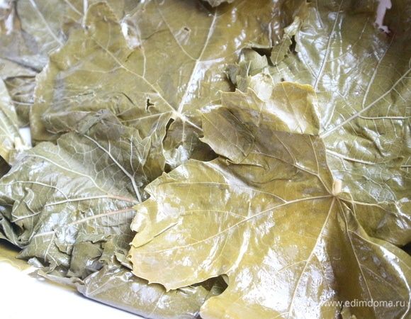 Форму слегка смазать оливковым маслом, поместить листья винограда сначала для одной рыбки. 