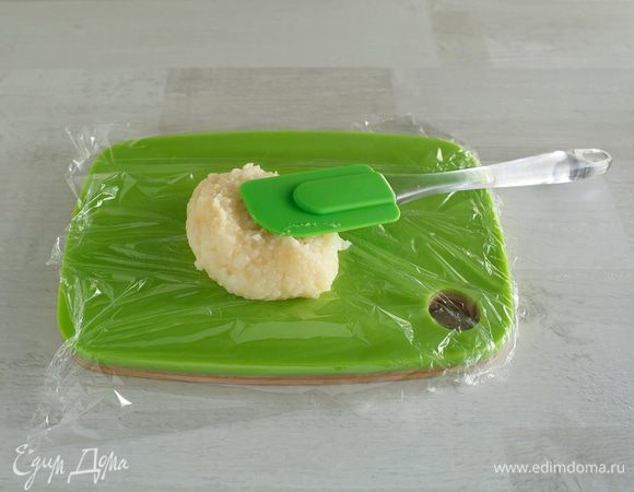 Силиконовой лопаточкой (к ней не прилипает) аккуратно кладем рис на пищевую пленку.  Руками стараемся не трогать.