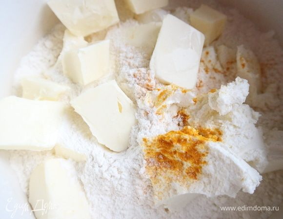 Муку  просеять. Добавить к муке соль, куркуму, холодное сливочное масло, нарезанное кусочками.