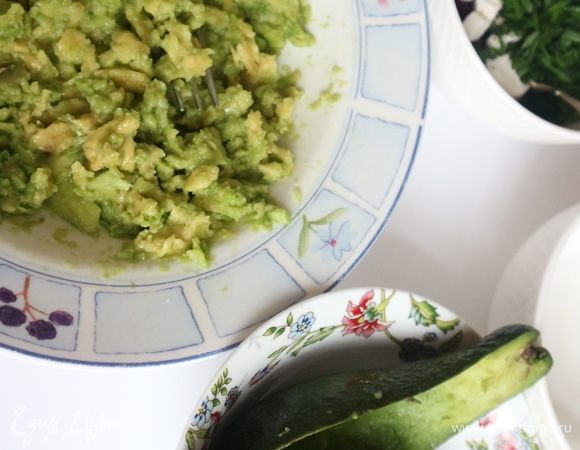 Мякоть авокадо вынуть ложкой, в тарелке вилкой размять мякоть авокадо, добавить лимонный сок, размешать. 