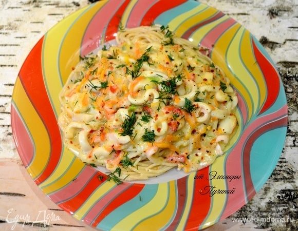 Готовые спагетти выложить в центр тарелки и сверху полить нашей нежной подливой с кальмарами, посыпать зеленью и перцем.