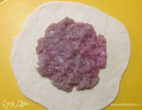 Столовой ложкой выкладываем начинку по центру раскатанной лепешки, разравниваем ее пальцами.