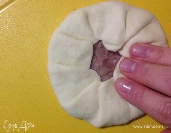 Затем подтягиваем края теста к центру, собирая тесто защипами по кругу, оставляя открытый кружок посередине.
Готовый беляш разравниваем пальцами по кругу, слегка придавливая.