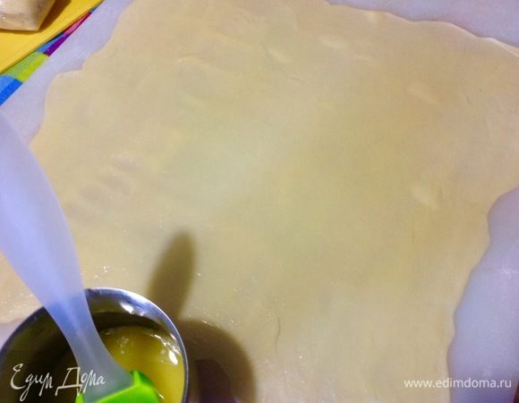 Одну часть теста забираем для раскатки, остальные заворачиваем обратно в пленку, и так каждый раз.
Кусочек теста раскатываем очень тонко, с этим тестом приятно работать, поэтому и раскатывается тонко оно легко.
50 г сливочного масла надо растопить, и теперь смазываем растопленным маслом раскатанный пласт теста. Посыпаем через маленькое ситечко кукурузным крахмалом по всей поверхности пласта теста, можно заменить на картофельный крахмал или посыпать молотыми сухарями, это для того, чтобы штрудель не протекал при выпечки, яблочный у меня почти не тек, а вот с вишней все равно протекал, но это его не испортило совсем. Я не использую сухари для посыпки, потому что, мне кажется, что сухари придают плотность стенкам штруделя. Это мне совсем не нравится, поэтому использую кукурузный крахмал, при остывание крахмал как бы собирает весь сок и превращает в легкое желе, это больше в моем вкусе, но каждый решает сам, что ему больше подходит.