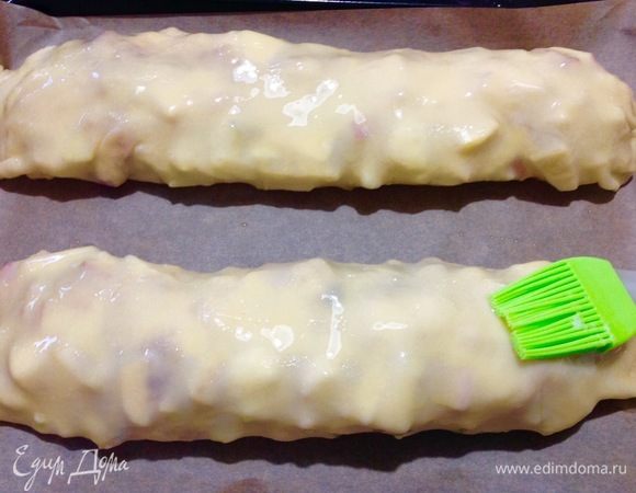 Выкладываем свернутый штрудель сразу на лист пергамента на противне.
Так же сворачиваем второй штрудель с яблоками и выкладываем рядом на противень. Смазываем растопленным сливочным маслом оба штруделя. Духовку предварительно нагрели на 200°С, выпекала я штрудели 40 минут.