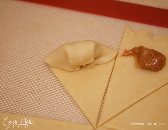 Свернуть рогалик: загнуть края к центру, «запечатать» начинку, свернуть рогалик, слегка прижать.