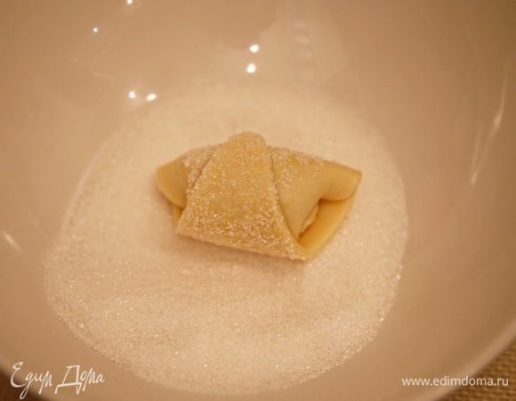 Сахар пересыпать в глубокую тарелку. Обмакнуть каждый рогалик в сахарном песке.
