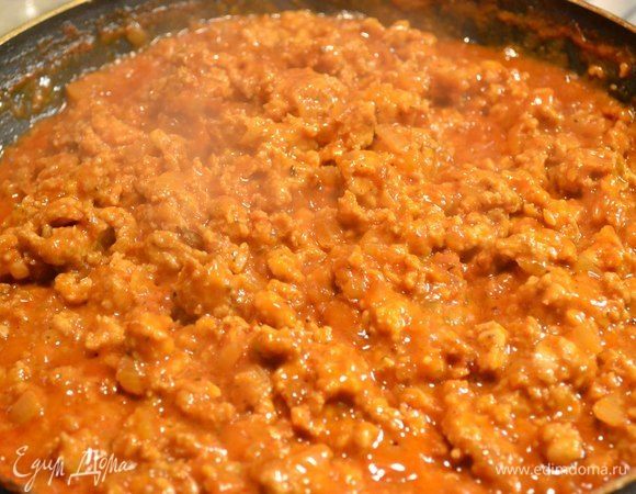 Готовим мясной соус: мелко нарезать лук кубиком, обжарить, добавить фарш, специи, томатный сок или томаты протертые, все тушим до испарения жидкости.