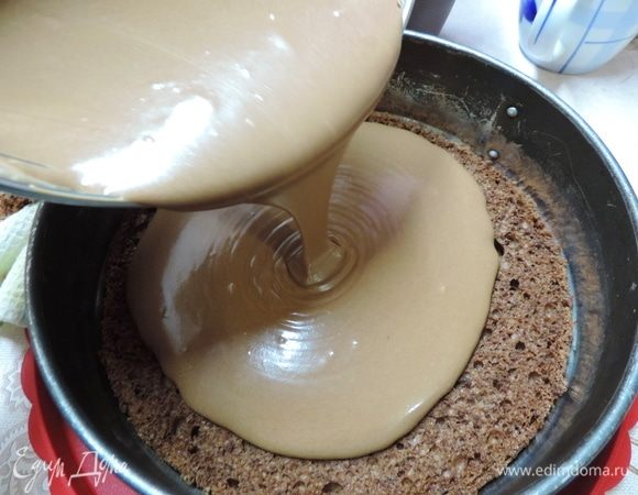 Бисквит кладем на блюдо и заключаем его в бортик от разъемной формы, в которой он пекся, или кулинарное кольцо. Выливаем на него полученный мусс и отправляем заготовку в морозилку.