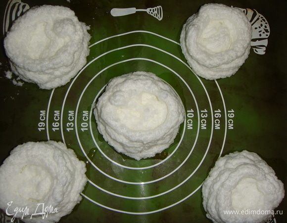 Противень застелить силиконовым ковриком или пергаментом. Белки выложить в кондитерский мешок и отсадить 5 «гнезд» на противень, делая повыше бортики.