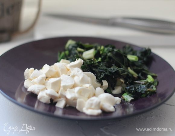 Натереть сыр на крупной терке или нарезать ломтиками. У меня мелкие шарики моцареллы — я их нарезала. Шпинат (если замороженный) разморозить и отцедить.
Шпинат нарезать и припустить: растопить в широком сотейнике  на среднем огне 25 г сливочного масла, выложить шпинат и готовить до мягкости. Снять с огня. Поставить сотейник на подставку на стол. Смешать сыр, рыбу, шпинат и сырое яйцо. Посолить по вкусу.