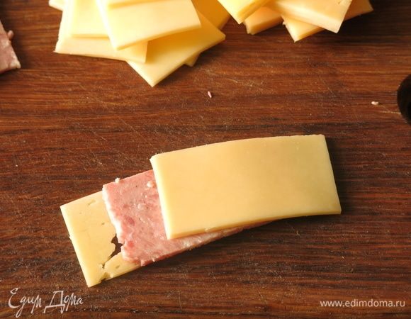 Складываем по два кусочка сыра и колбасы.