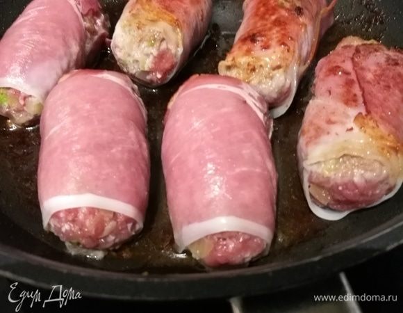 Из фарша сформировать небольшие колбаски и обернуть их в ломтики сыровяленной ветчины (в идеале пармской, но подойдет и любая другая ветчина). Рулетики слегка обжарить в разогретом оливковом масле.
