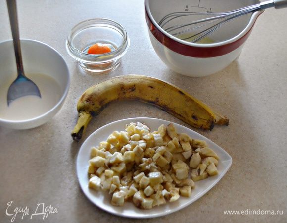 Банан почистите и нарежьте мелкими кубиками. Желток отделите от белка. Белок взбейте в пену. Фундук очистите и порубите в крошку.