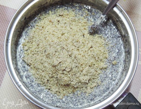 Вводим желтковую смесь в теплый мак, добавляем туда же молотые орехи и перемешиваем.