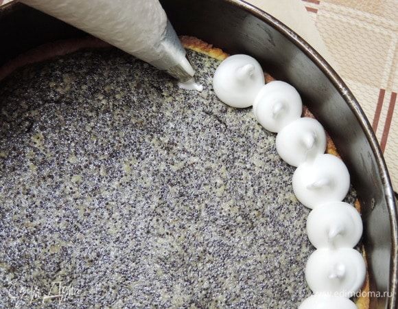 Заполняем белковой массой кондитерский мешок с круглой насадкой и отсаживаем пики сверху на маковый слой. Если лень возиться с мешком и насадкой, можно просто распределить безе сверху по пирогу и ложкой сделать «волны».